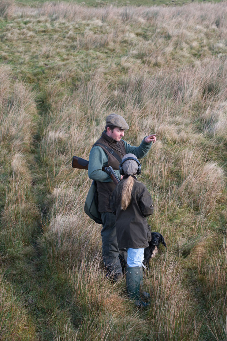 Man and daughter on a rough shoot. the father is explaining what is happening
